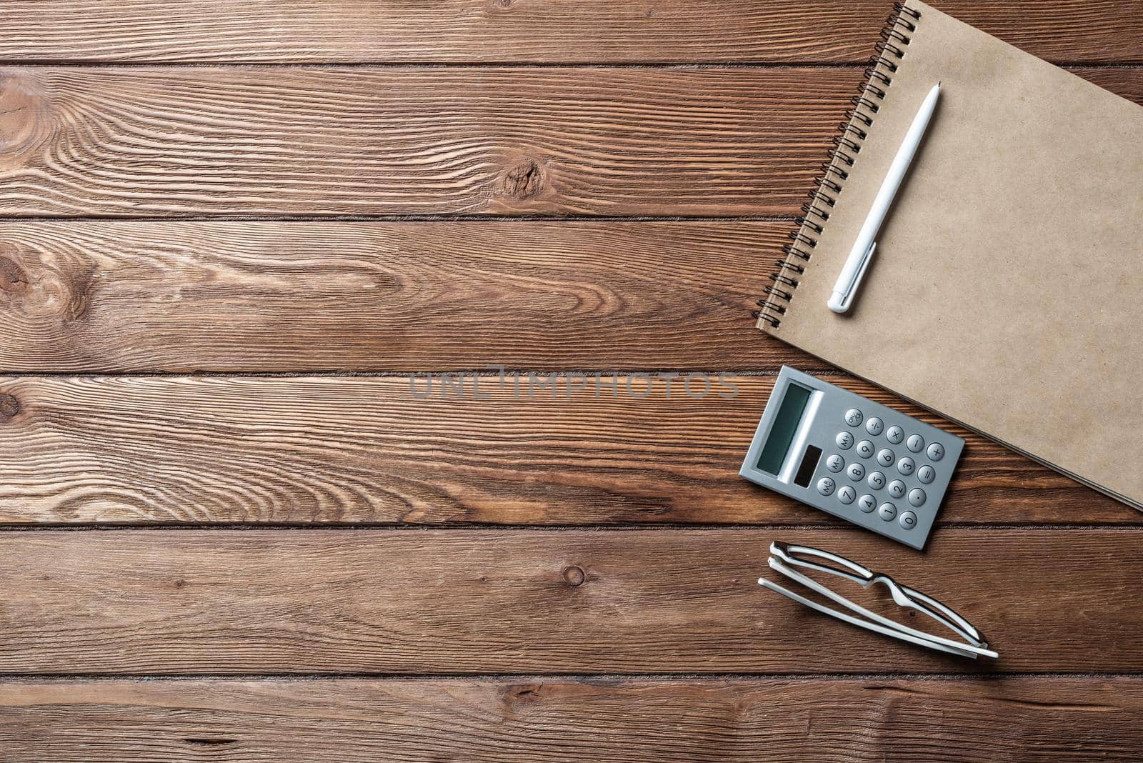 Still life of accountant vintage workspace with office accessories. Flat lay old hardwood desk with notepad, pen and calculator. Accounting and banking services. Finance and investment concept.