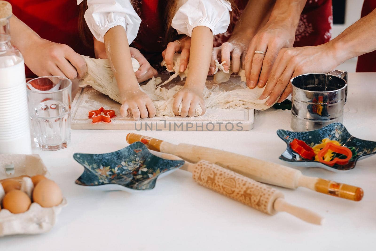 Close-up of hands cooking dough on the Christmas kitchen table by Lobachad