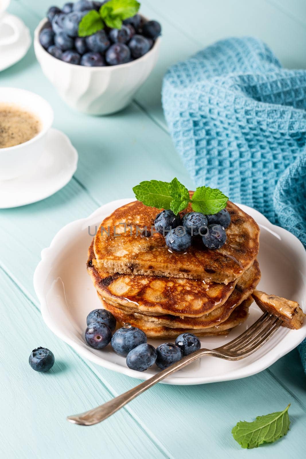 Delicious pancakes with chocolate drops, honey and blueberries. Healthy breakfast concept.