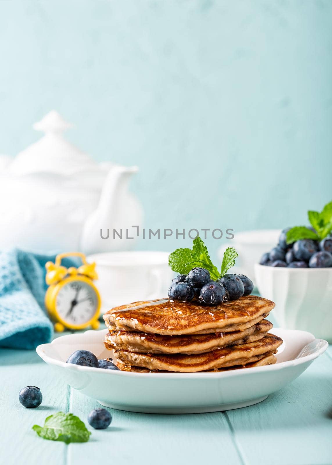 Delicious pancakes with chocolate drops, honey and blueberries. Healthy breakfast concept with copy space.