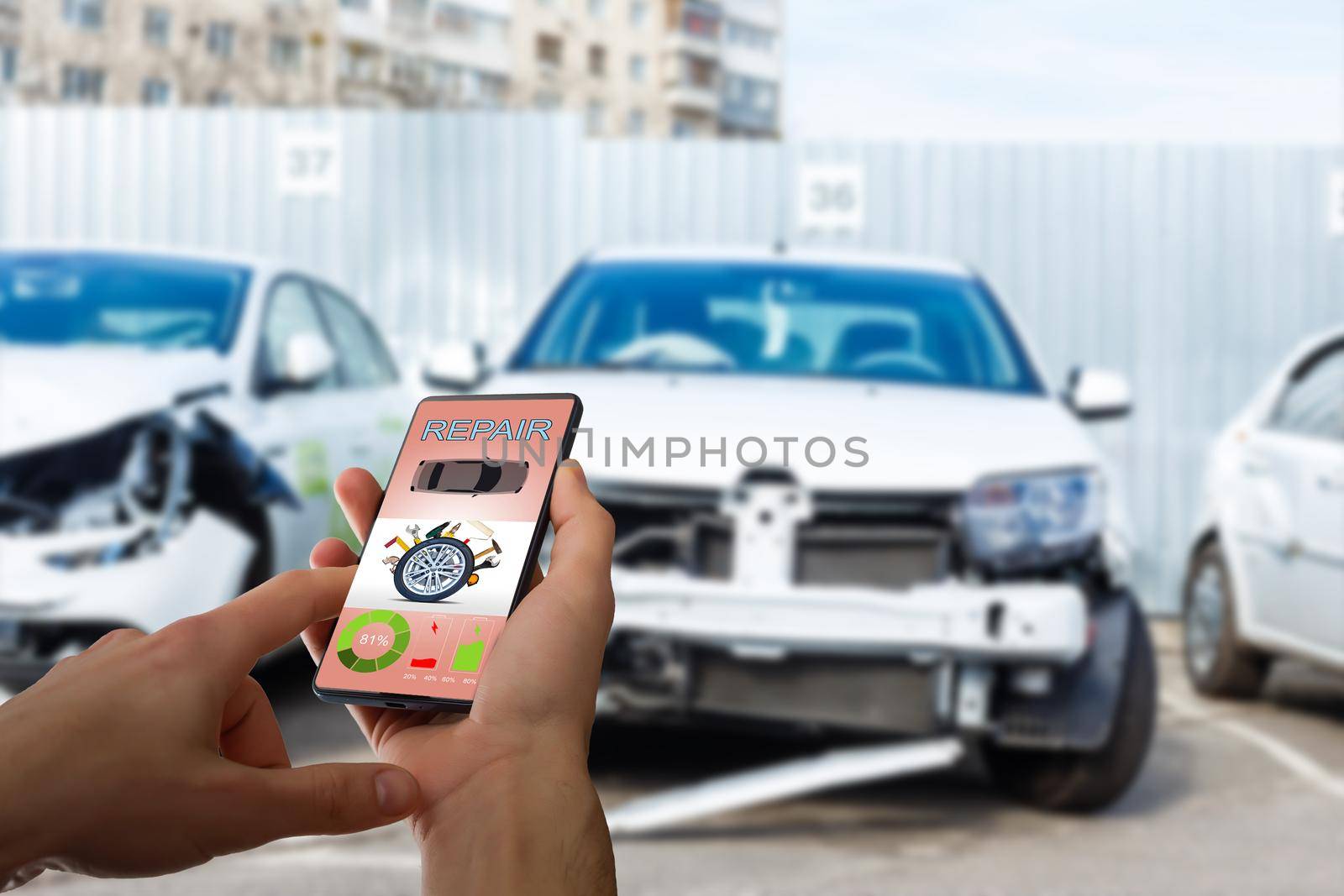 Mobile phone in hand on car repair service center blurred background.