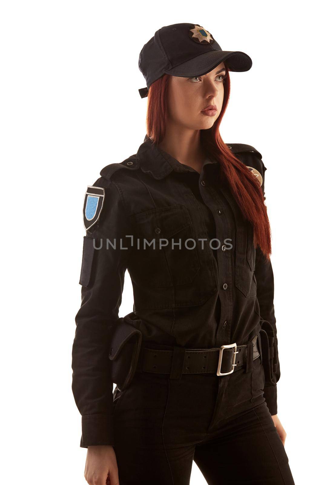 Redheaded female police officer is posing for the camera isolated on white background. by nazarovsergey
