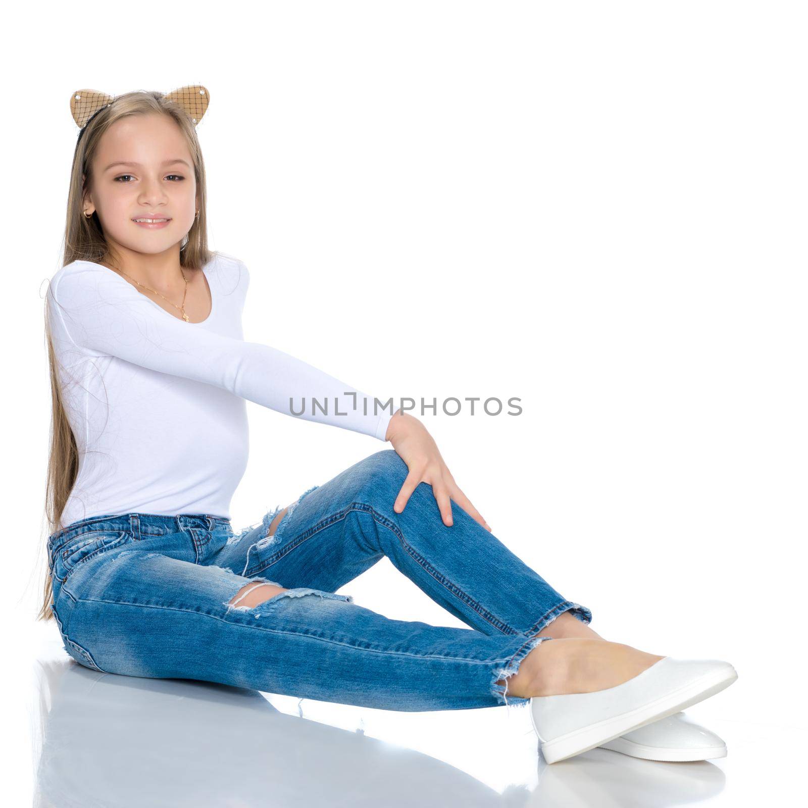 Beautiful teen girl in jeans with holes. Concept of happy childhood, fashion and style. Isolated on white background.