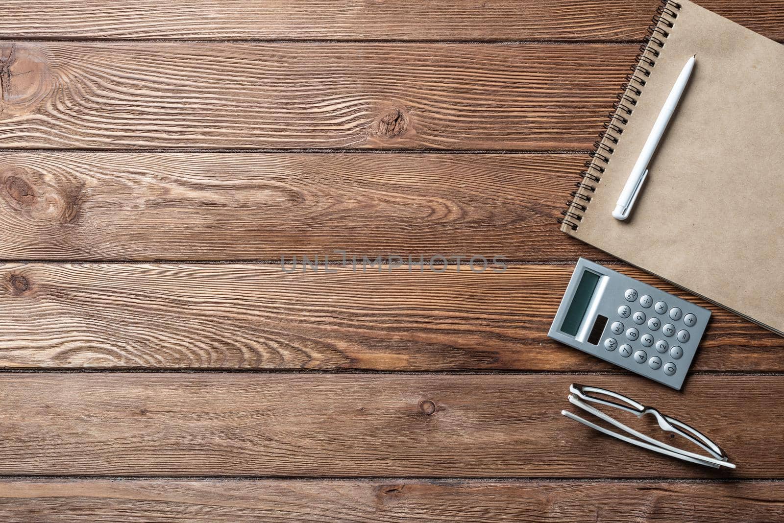 Still life of accountant vintage workspace with office accessories. Flat lay old hardwood desk with notepad, pen and calculator. Accounting and banking services. Finance and investment concept.