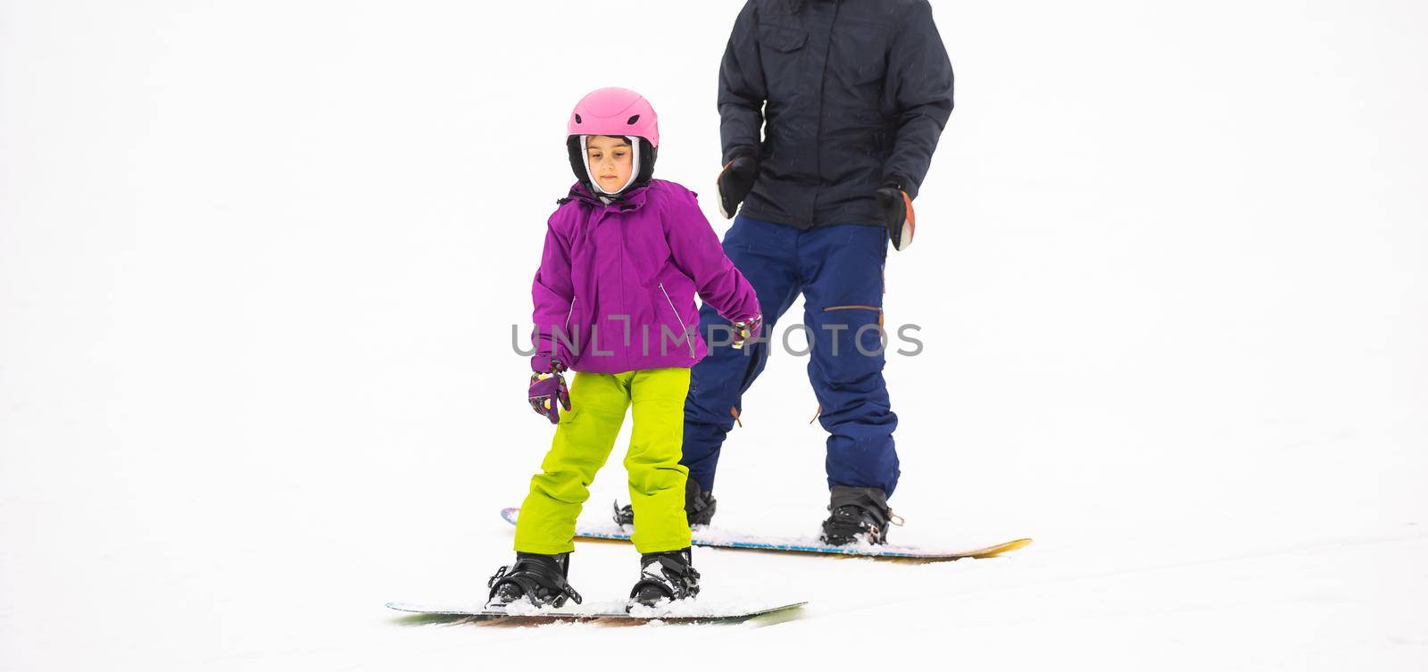 At Cold Winder Day at Mountain Ski Resort Father Teaching Little Daughter Snowboarding