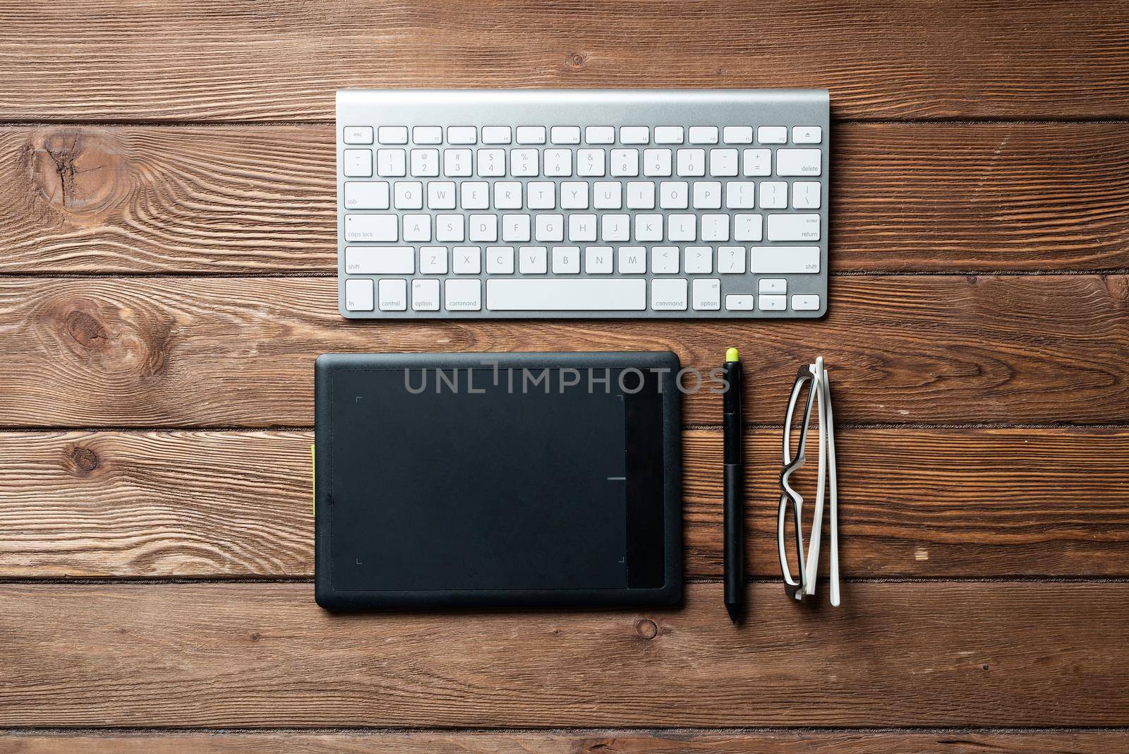 Top view office workspace composition. Flat lay vintage wooden desk with pc keyboard and graphic drawing tablet. Design and creativity. Time management and planning. Designer workplace organization.