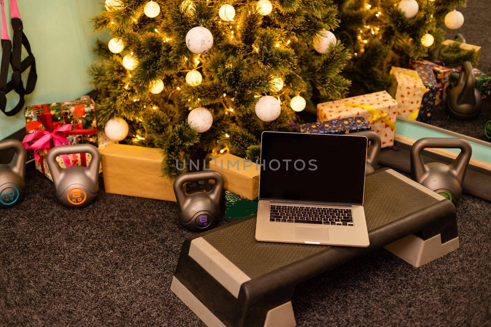 Sport accessories. Dumbbells, computer tablet, fir tree branches and Christmas decorations on background. Top view with copy space. Fitness, sport and healthy lifestyle.