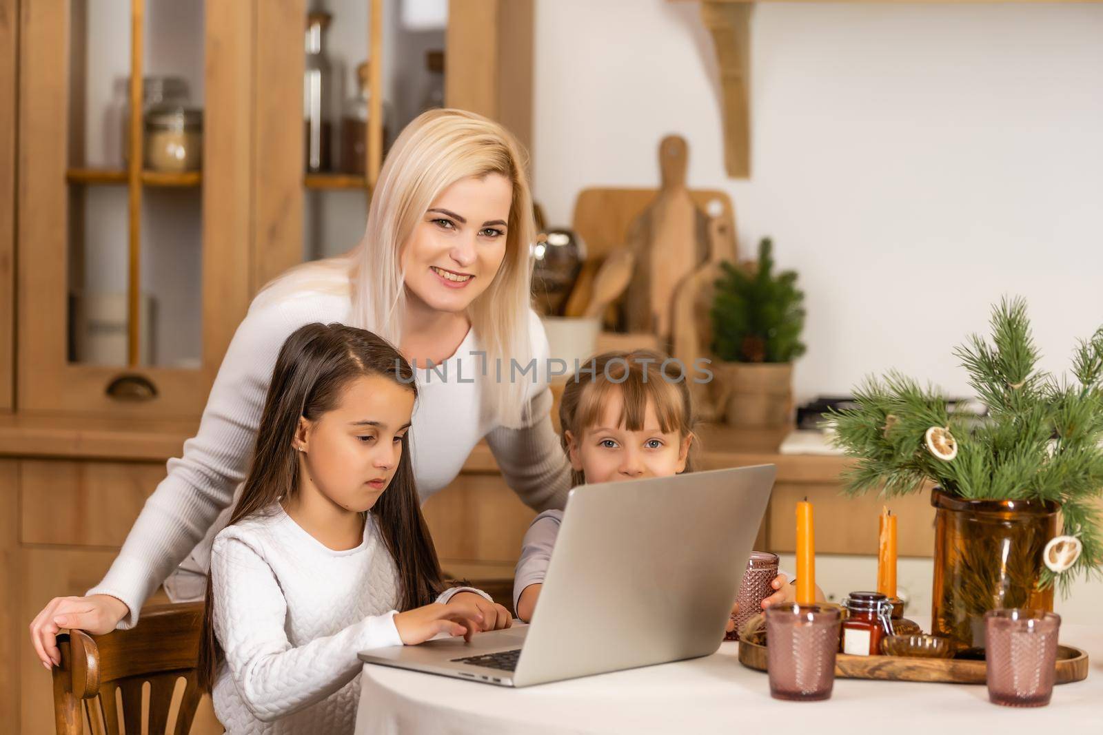 Homeschool. young two little daughters learning internet online, do homework by using computer with mother help, teach and encourage. study education at home together by Andelov13