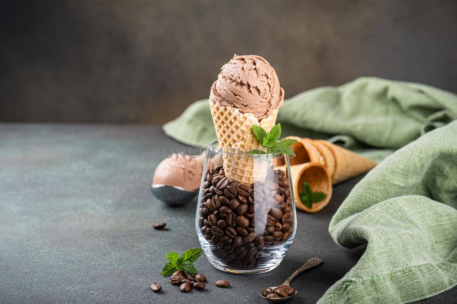 Delicious coffee or chocolate ice cream in waffle cone for dessert. Summer healthy food concept, lactose free. Copy space.