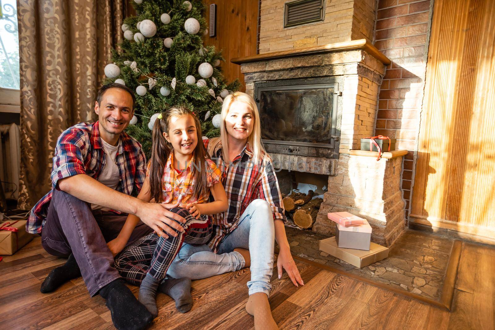 family and christmas tree in an old wooden house by Andelov13