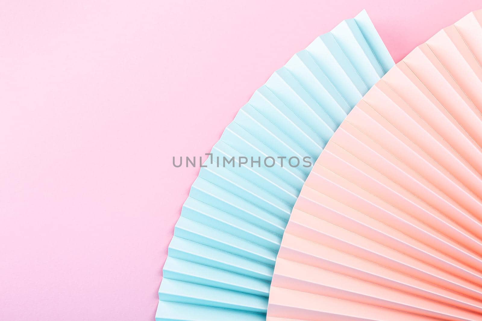 Colorful abstract background with paper fans, multicolored, light blue, pink and beige. Trend Concept. Top view, close up. Copy space