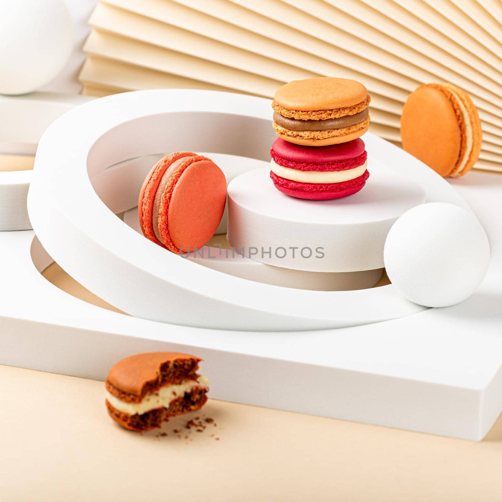 Colorful french macaron dessert. Set of various different tastes and color macaroon cookies with white circles on pink background. Festive greeting card concept with copy space