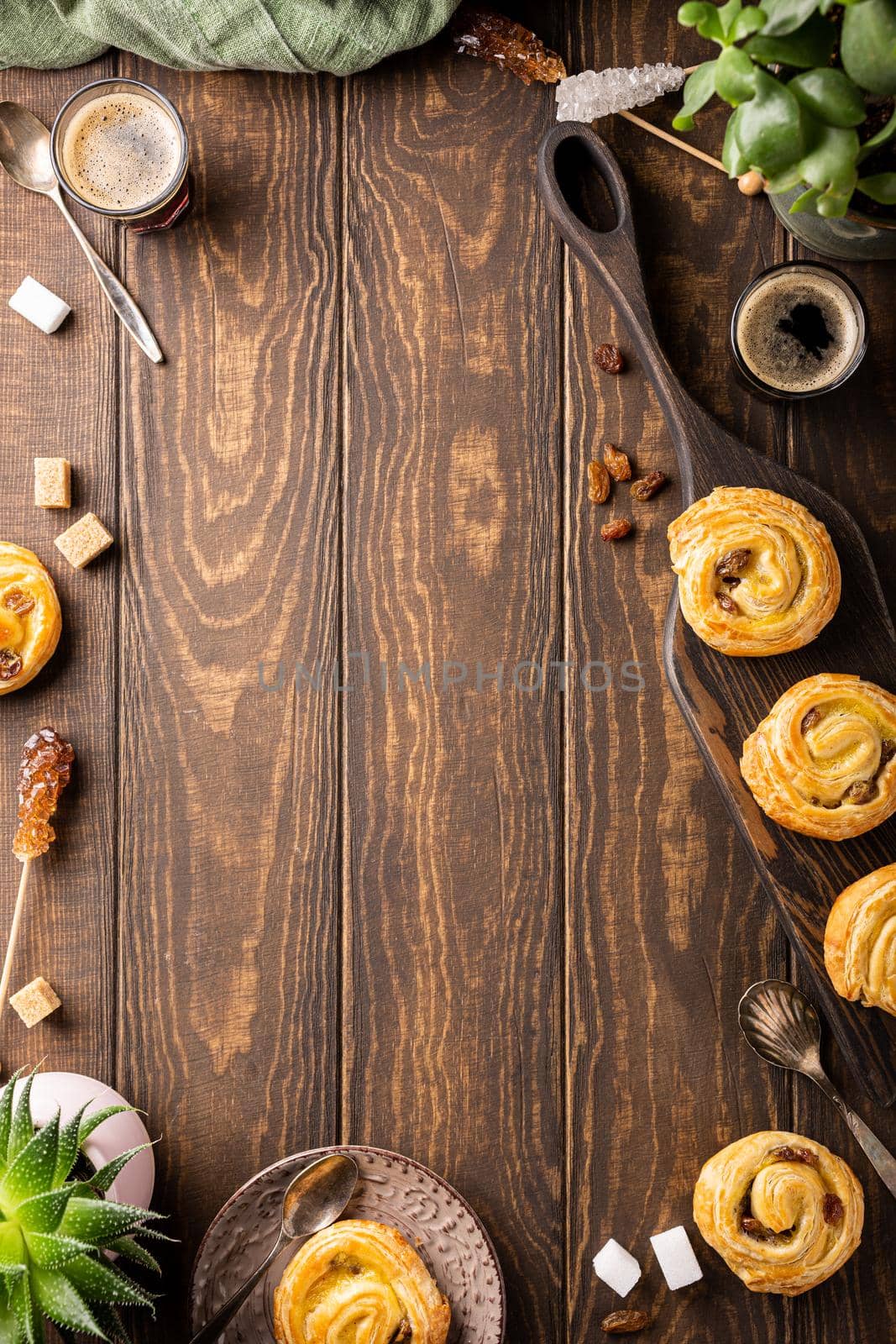 Food background with fresh pastry sweet swirl buns with raisins for breakfast or brunch and coffee. Top view, copy space.