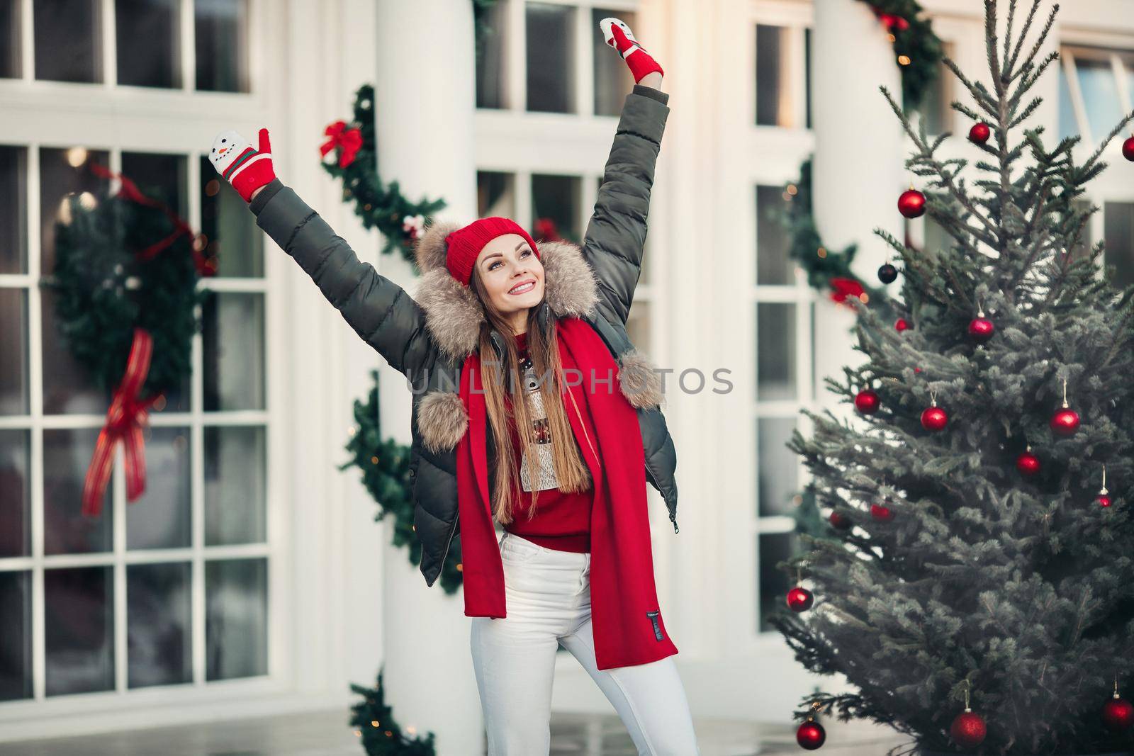 Belarus Minsk 16 12 2019:Beautiful winter young casual woman posing outdoor surrounded by snowflakes medium long shot. Happy beautiful girl enjoying Xmas mood at Christmas tree background having positive emotion
