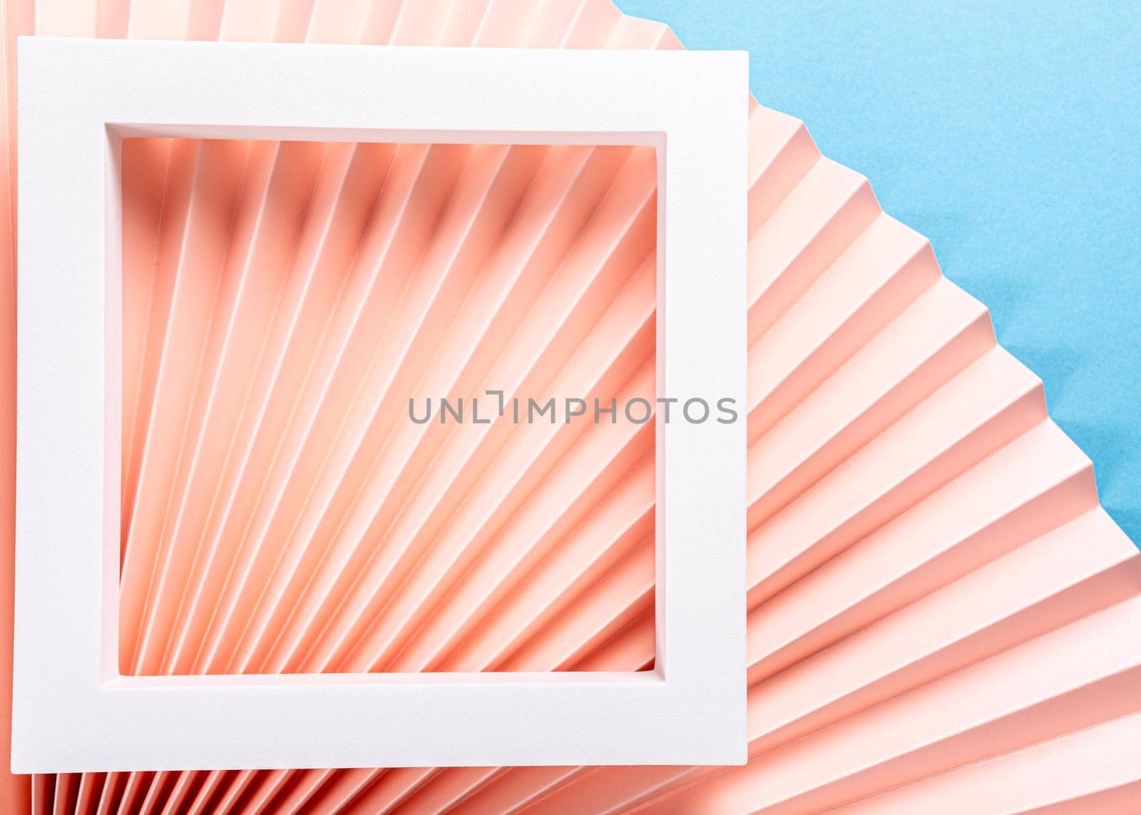 Colorful abstract background with pink paper fans and white frame. Trend Concept. Top view, close up, copy space