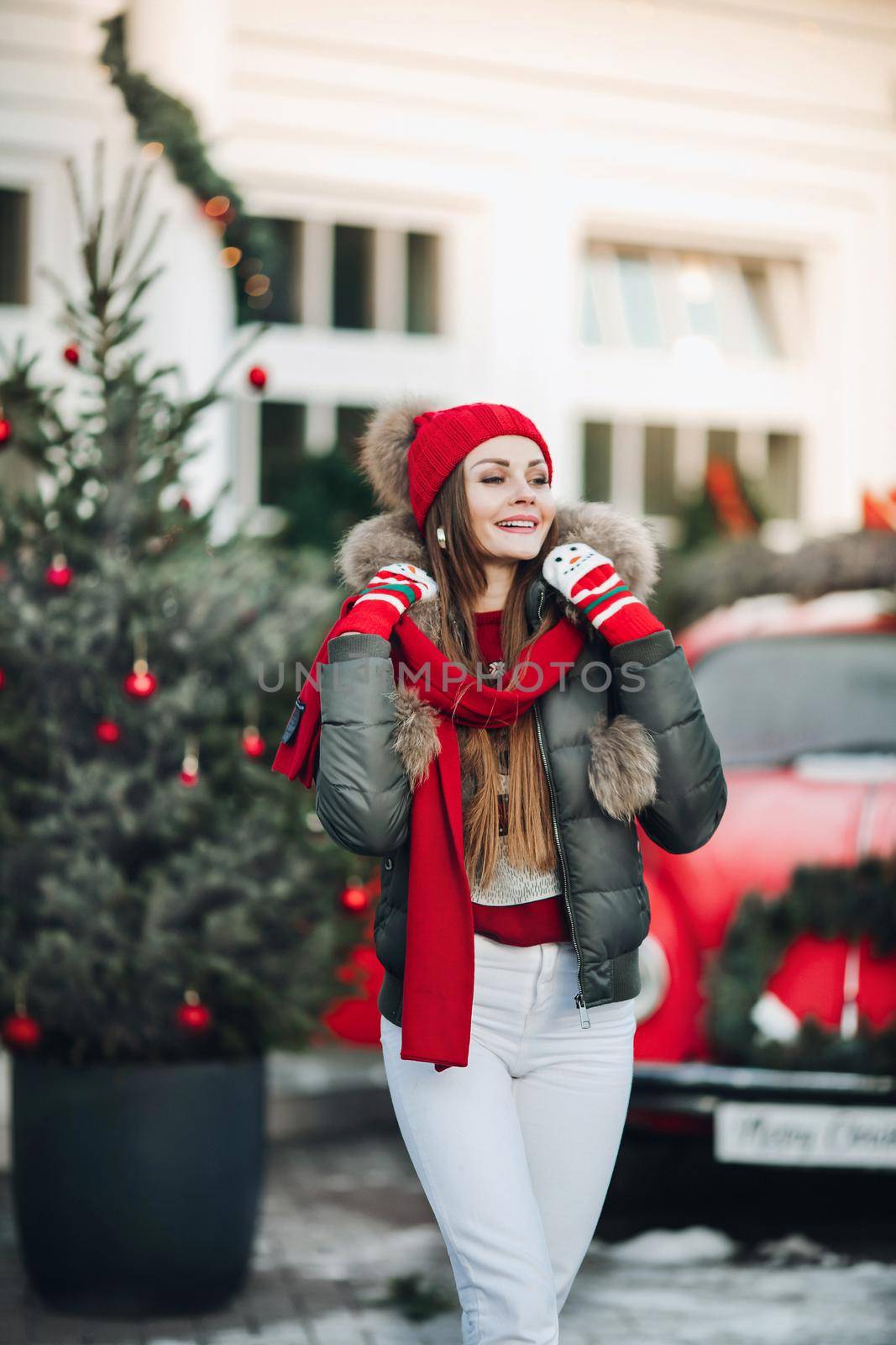 Belarus Minsk 16 12 2019:Beautiful winter young casual woman posing outdoor surrounded by snowflakes medium long shot. Happy beautiful girl enjoying Xmas mood at Christmas tree background having positive emotion