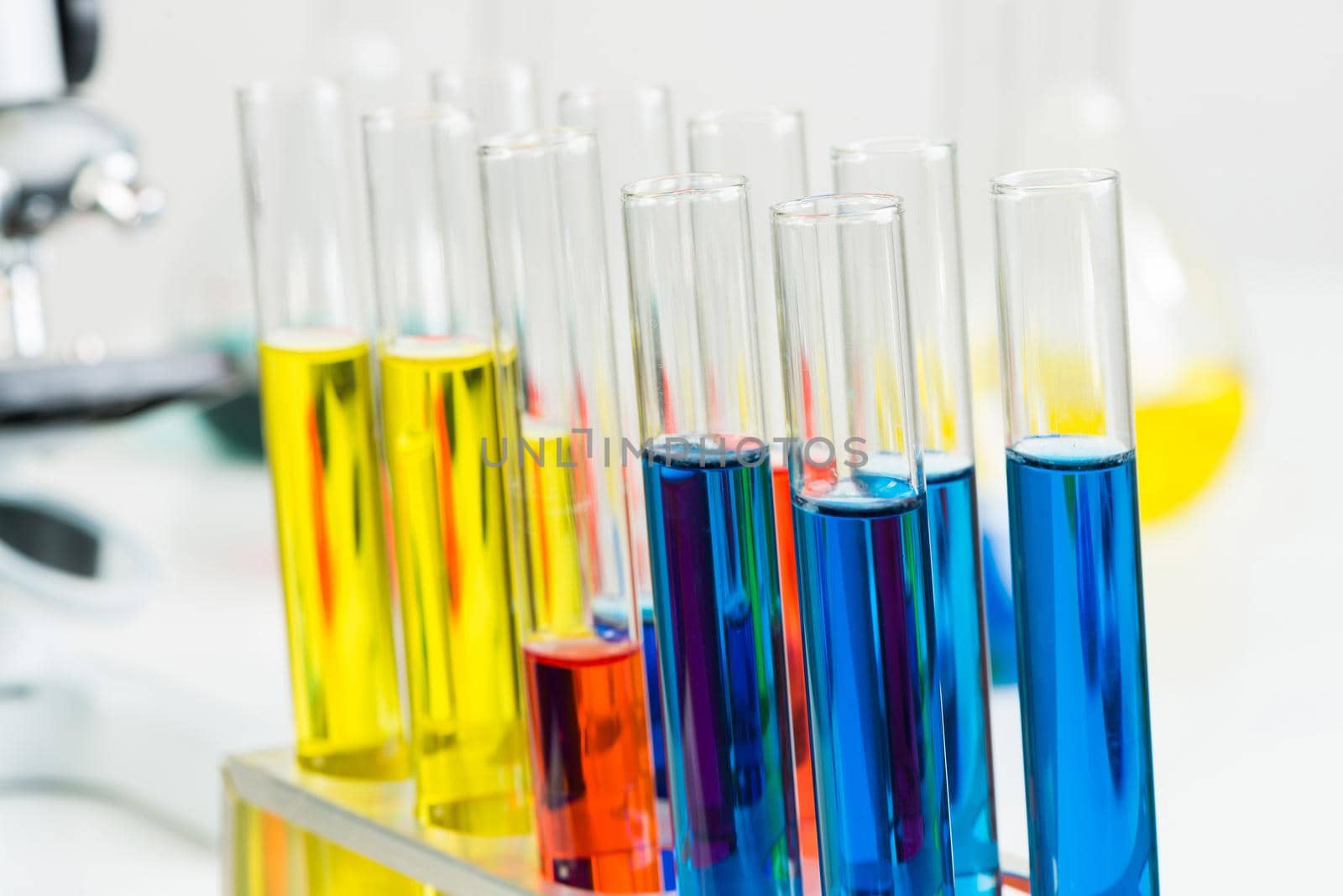 Science laboratory research and development. Modern biochemistry industry mockup. Close up test tubes with color liquid on white background. Chemical manufacture concept with glass equipment.