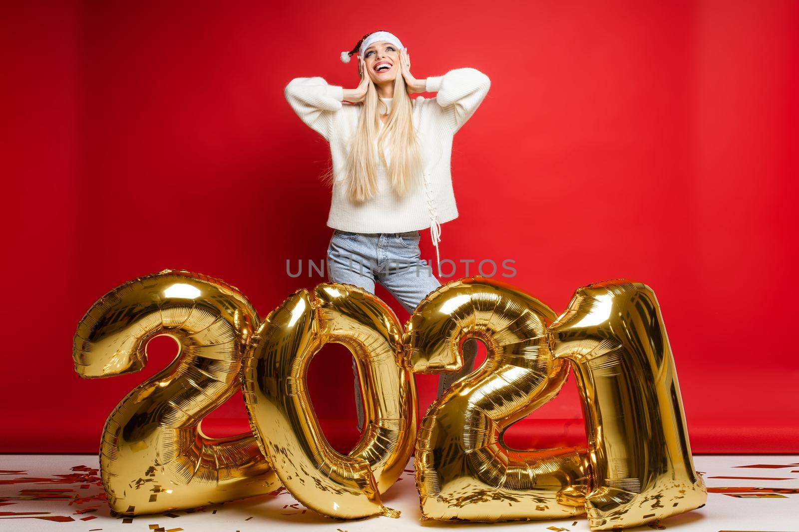 Dreamy happy caucasian girl in santa hat looking up make wish. Smiling female dream visualize happiness in 2021 New Year by StudioLucky