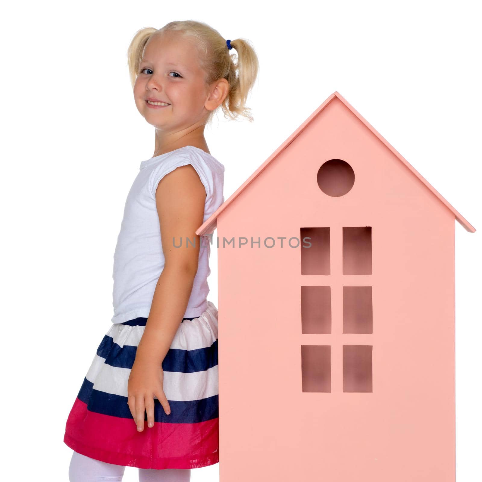 A cute little girl is playing with wooden houses. The concept of family happiness, play, creative development of the child.