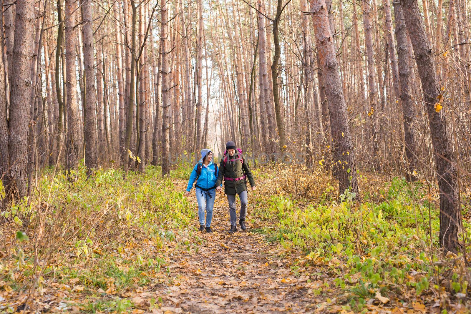 People, hike, tourism and nature concept - Couple tourist hiking in autumn forest.