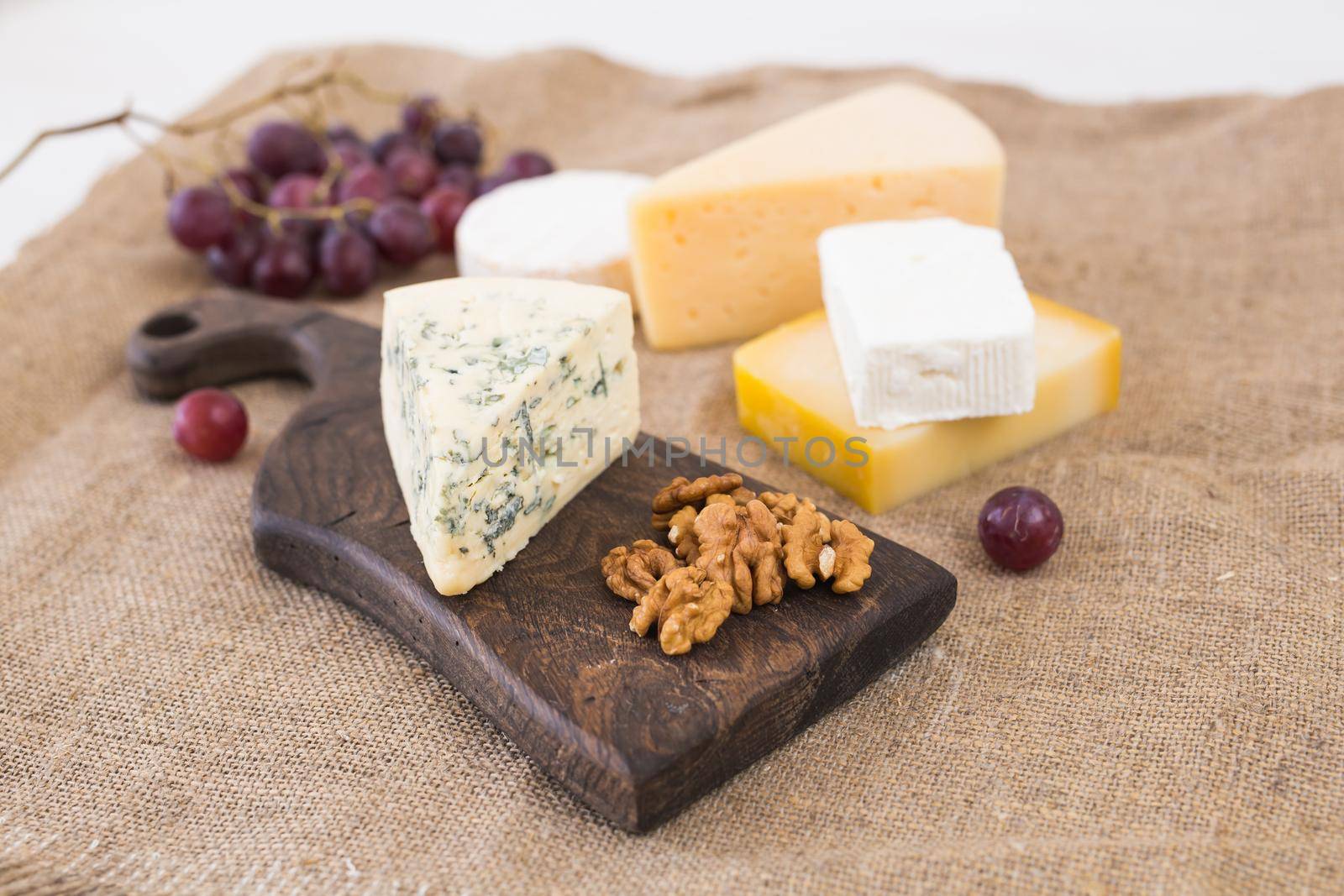 Fresh products. Cheese, brie, Camembert, grapes and nuts on rustic table. by Satura86