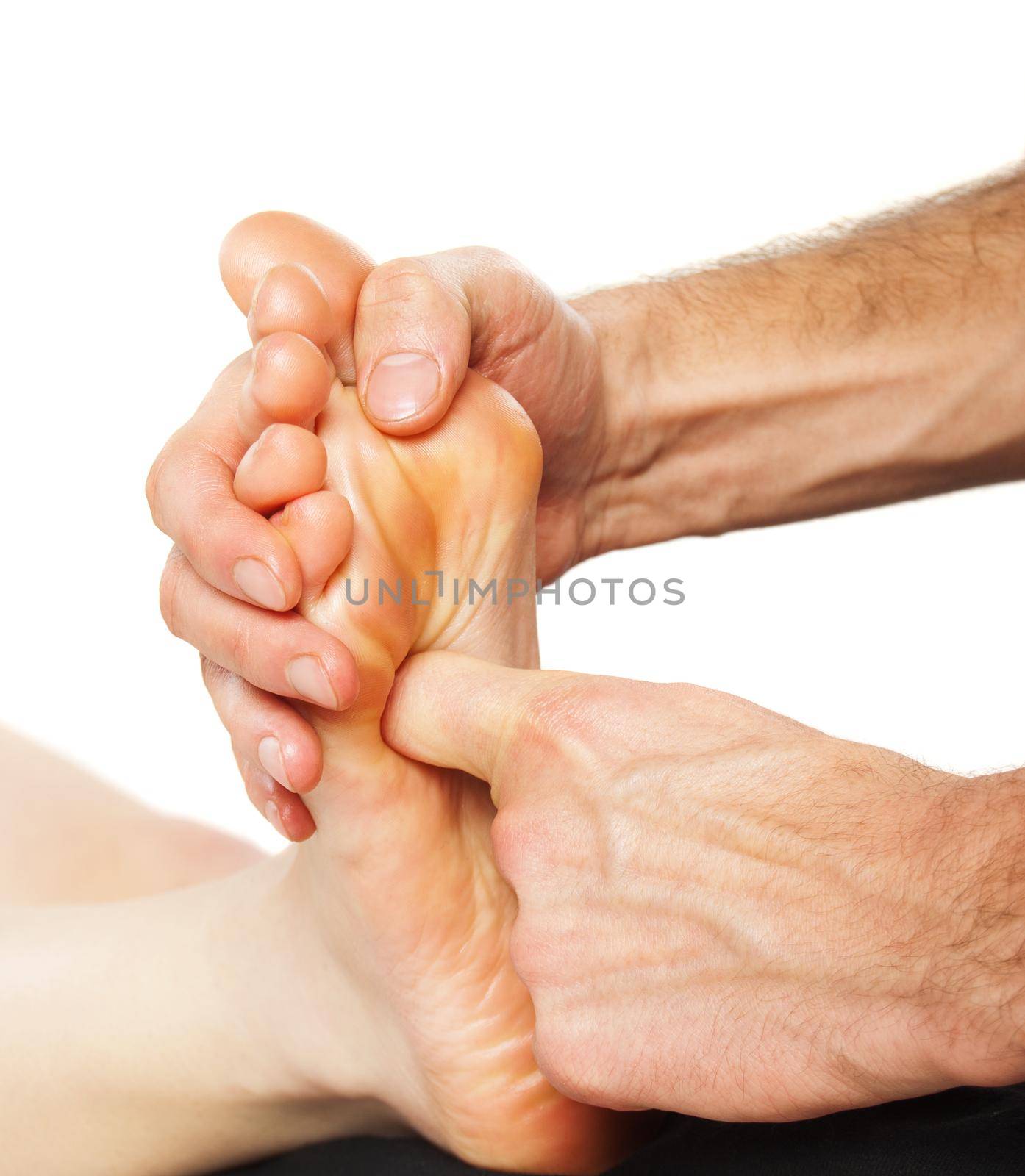 Closeup of foot receiving massage on white