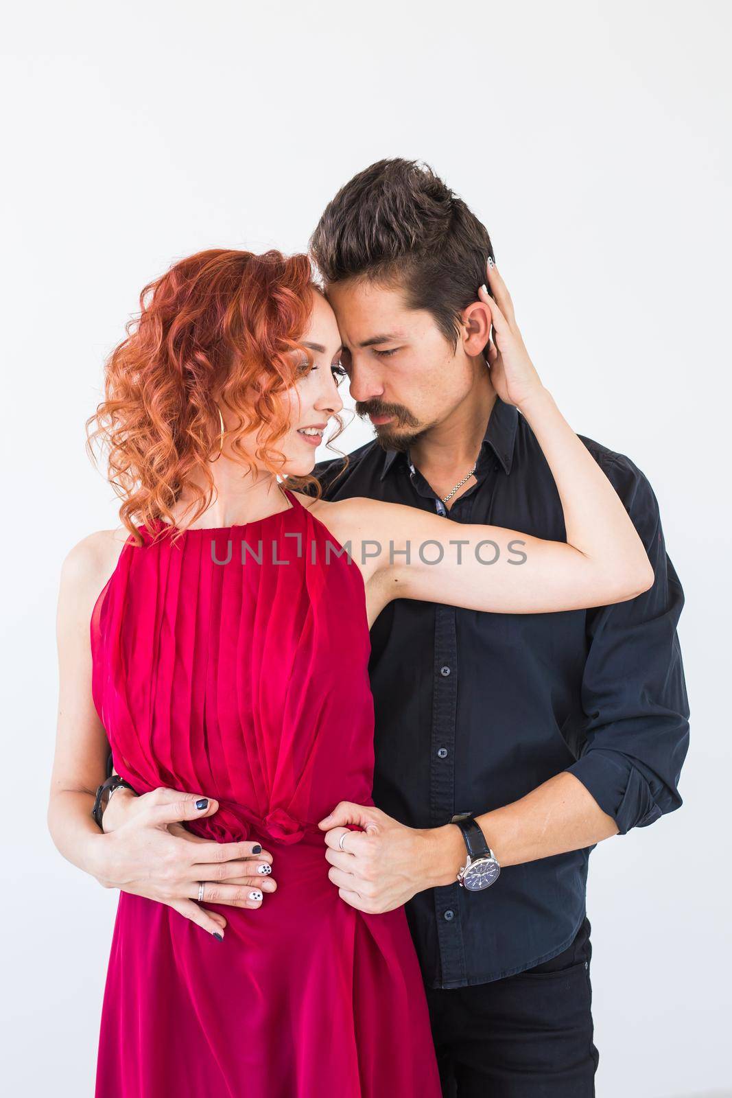 Romantic, social dance, people concept - couple dancing bachata in the studio, man hugging the woman from her back by Satura86