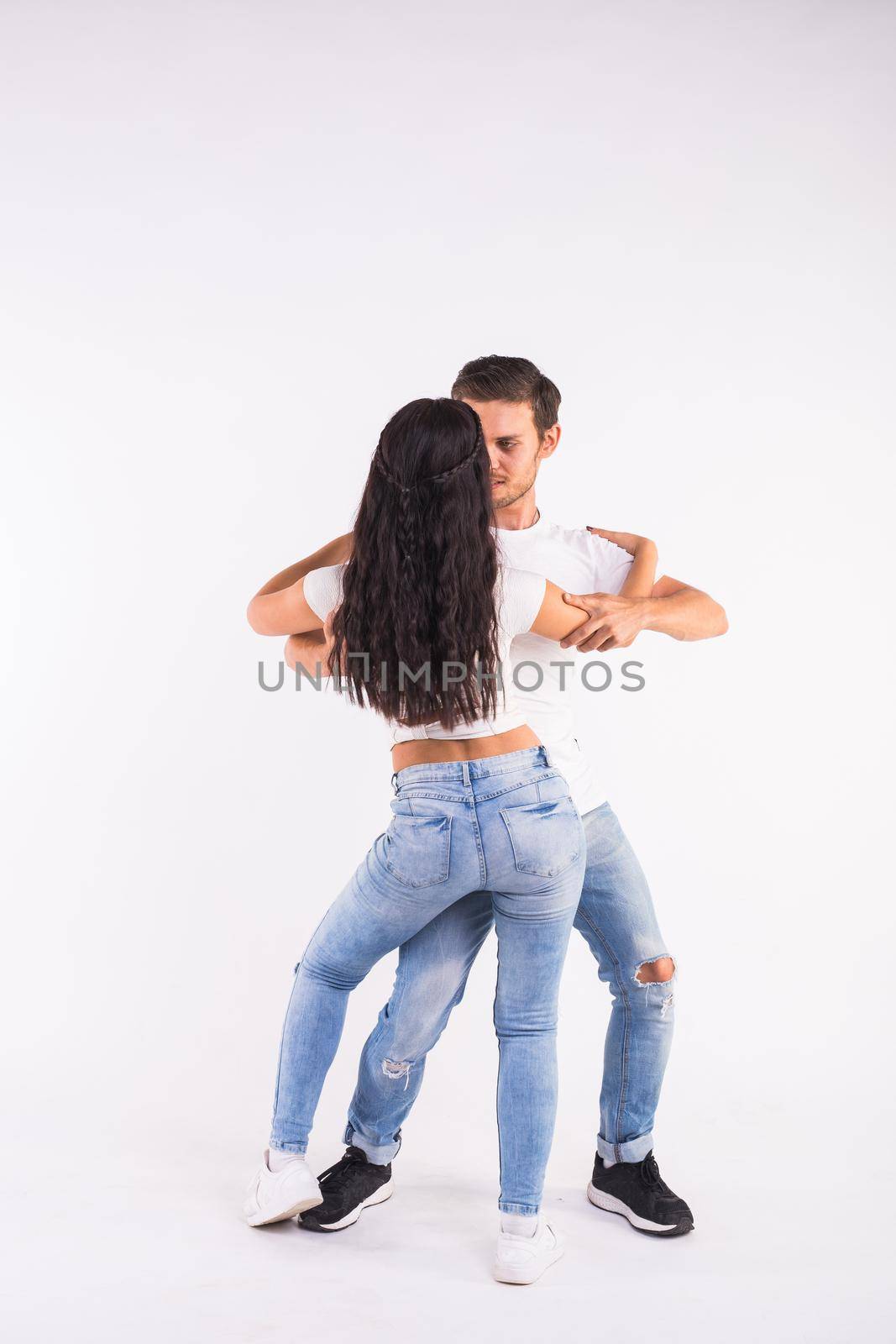 Young couple dancing social latin dance bachata, merengue, salsa. Two elegance pose on white background.