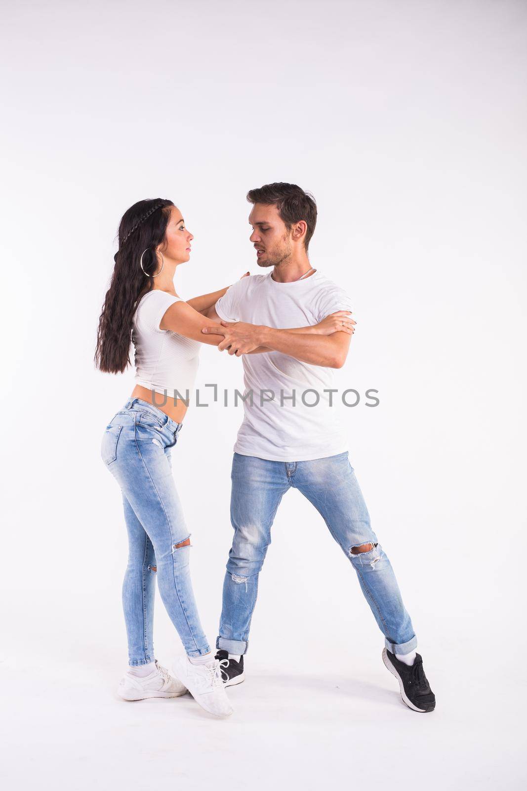 Passionate couple dancing social danse kizomba or bachata or semba or taraxia on white background.