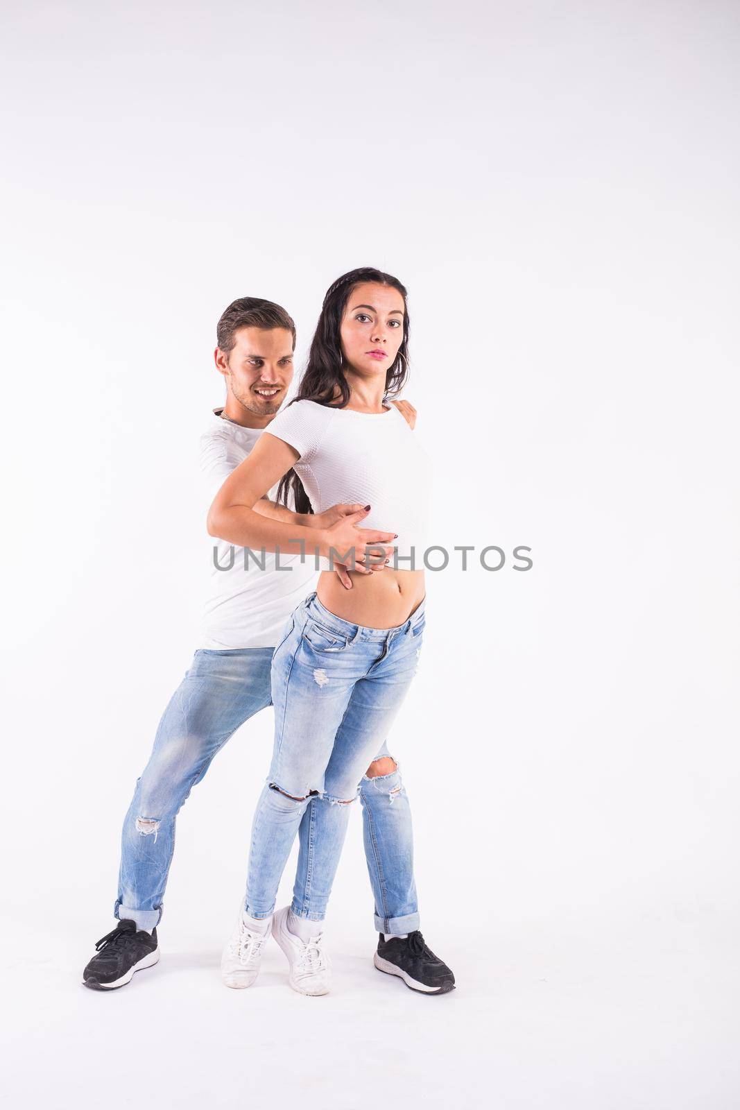 Young couple dancing social dance bachata, merengue, salsa, kizomba. Two elegance pose on white room