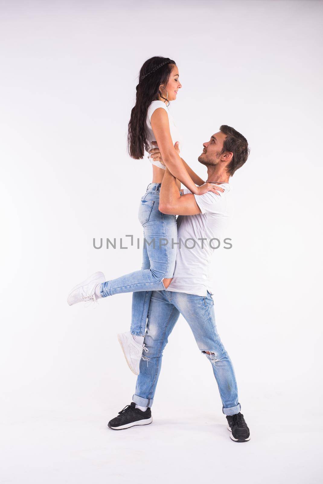 Passionate couple dancing social danse kizomba or bachata or semba or taraxia on white background.