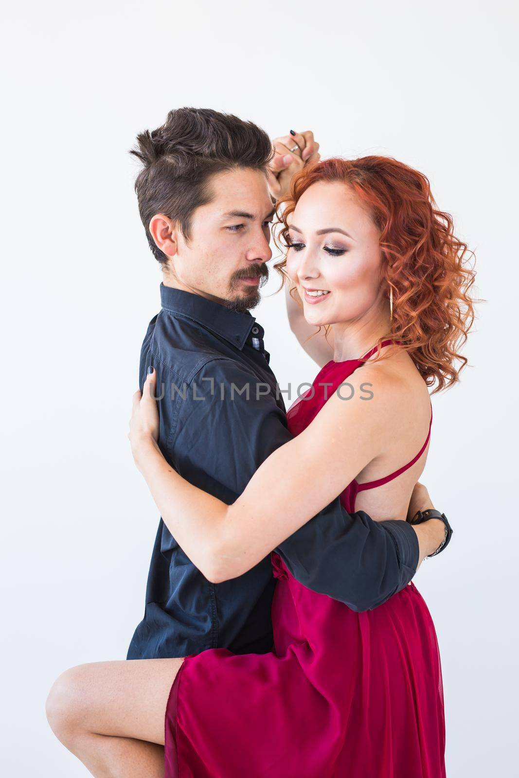 Social dance, bachata, kizomba, salsa, tango concept - Close up portrait of woman man dressed in beautiful outfits over white background.
