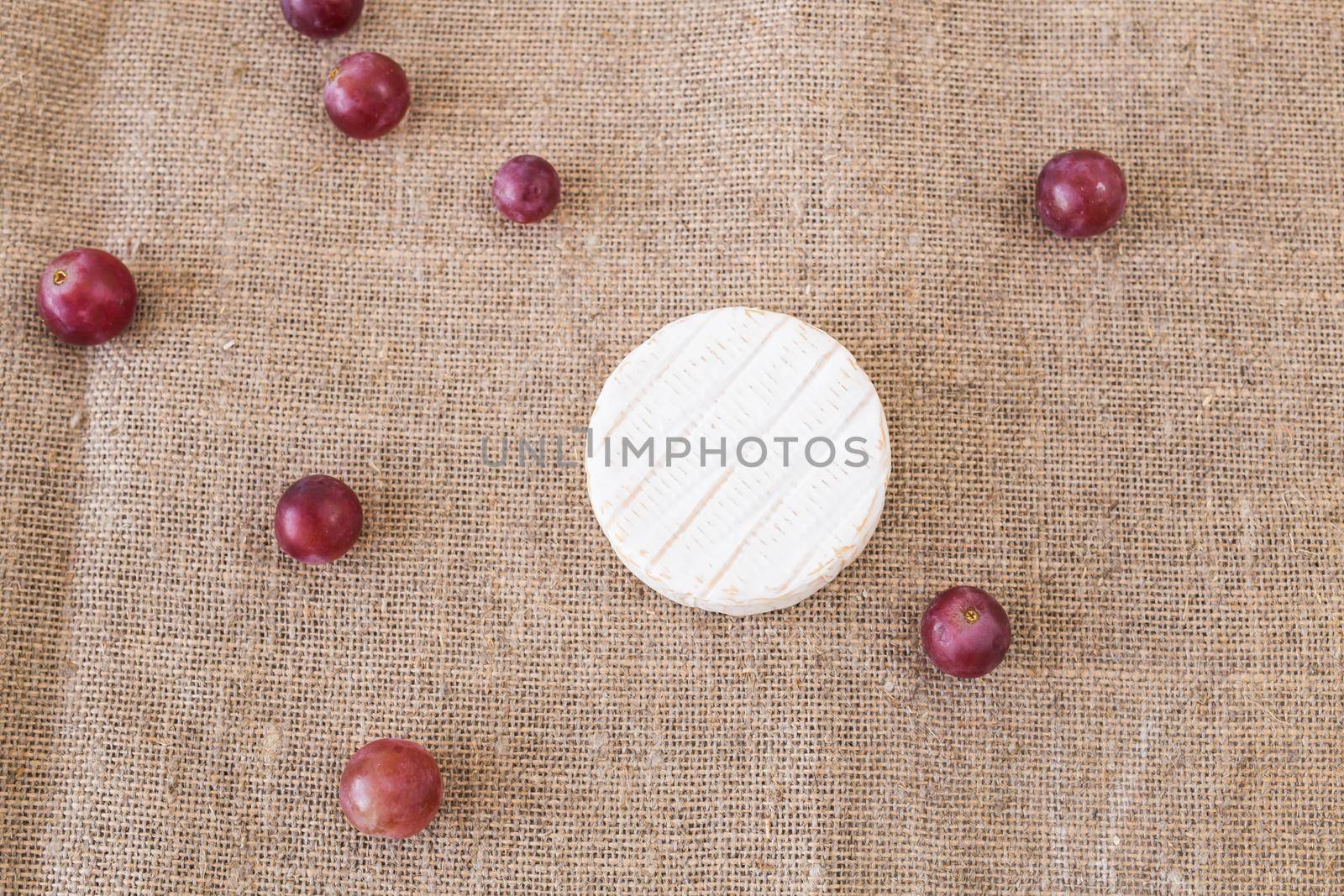Brie or camembert cheese with grapes on rustic background top view by Satura86