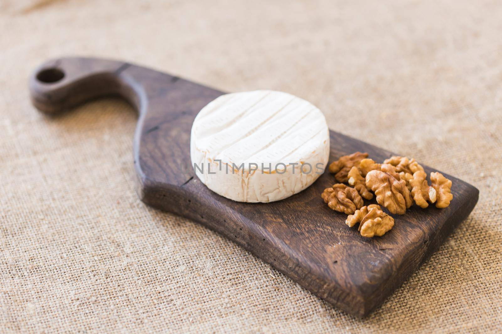 Brie or camembert cheese with figs, grapes and honey on wood