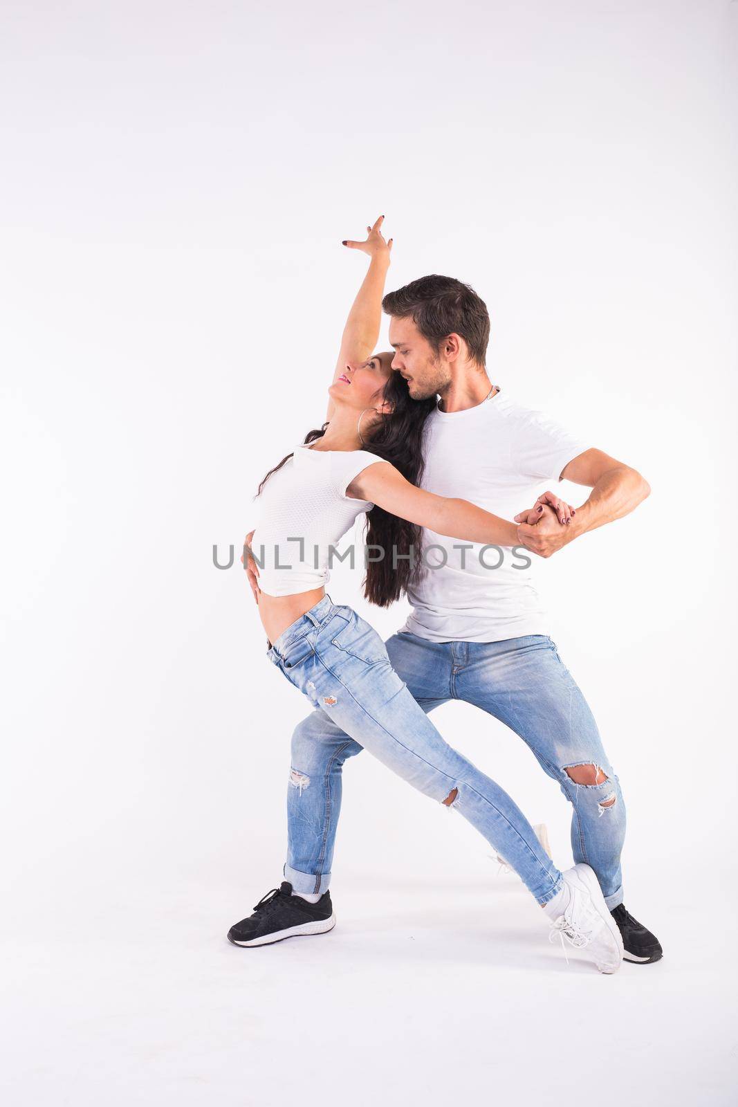 Young couple dancing social latin dance bachata, merengue, salsa. Two elegance pose on white background by Satura86