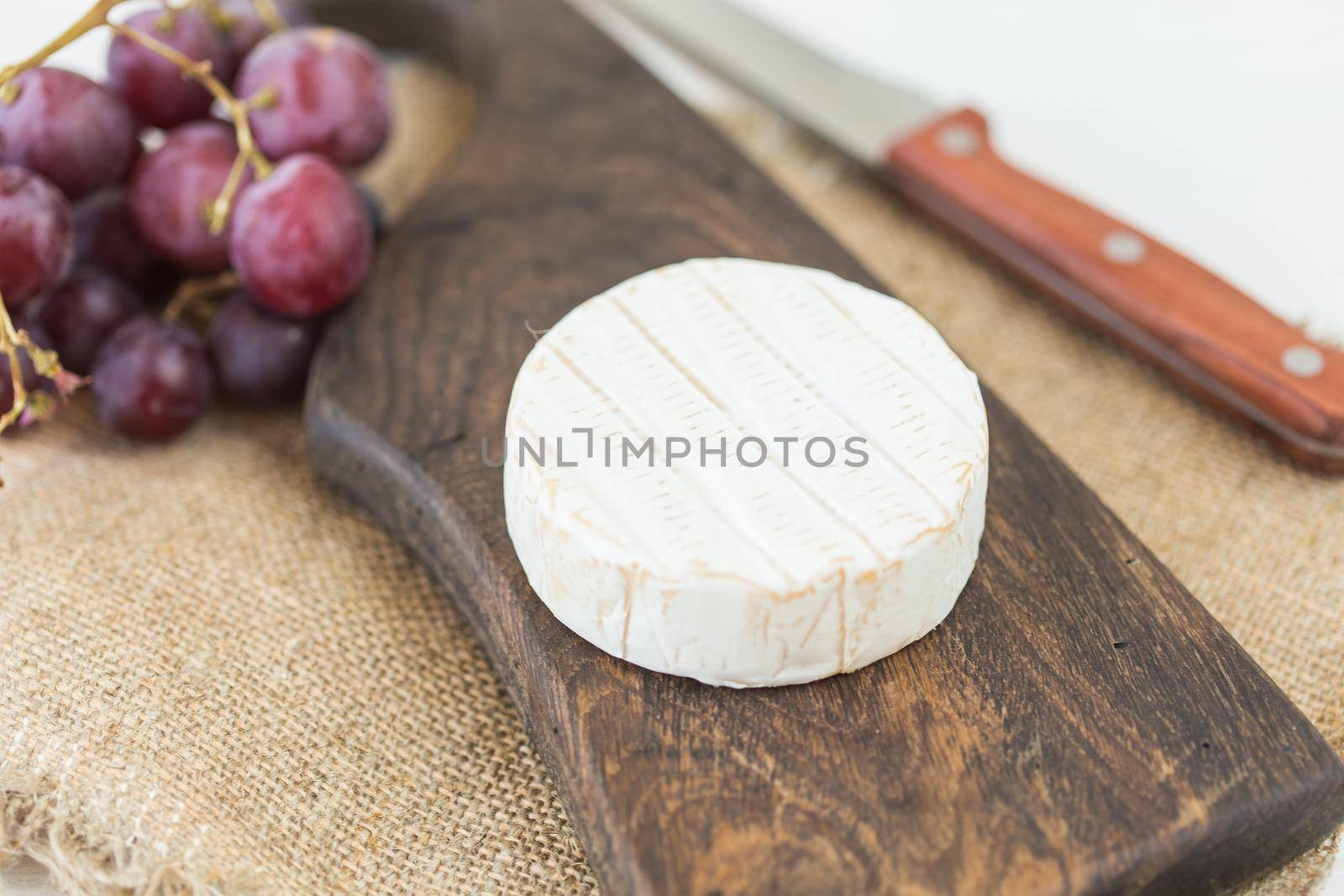 Cheese brie with on rustic wooden board by Satura86