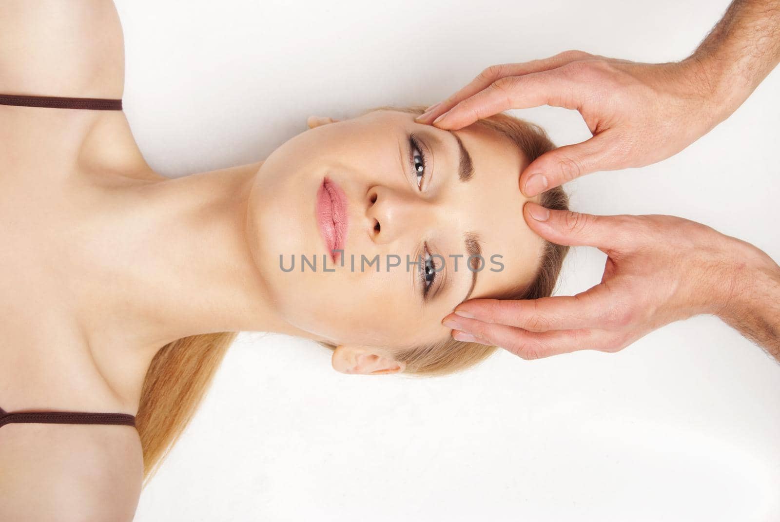 Young bright woman receiving a head massage in a spa centre