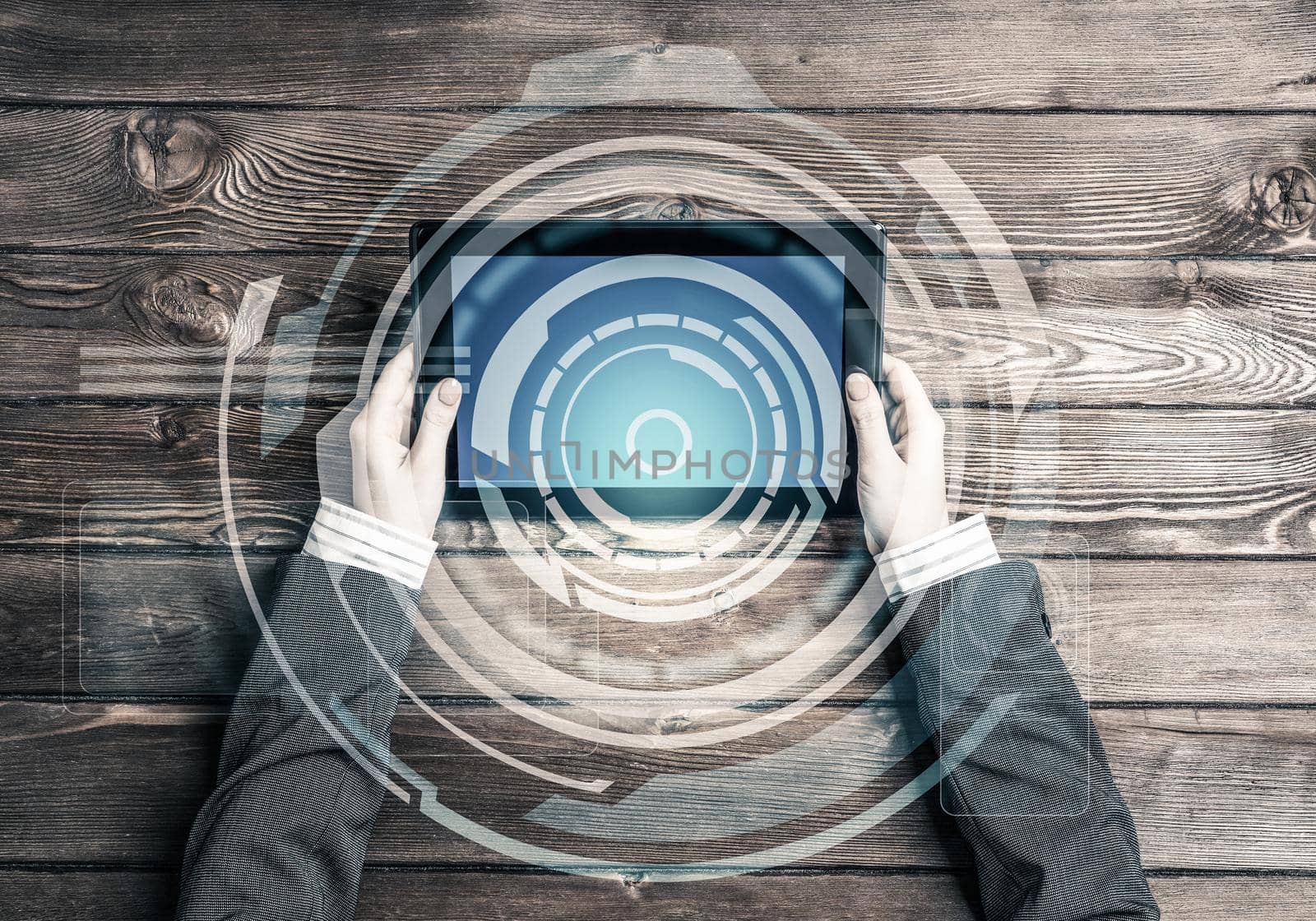 Top view of businesswoman sitting at wooden table with tablet pc