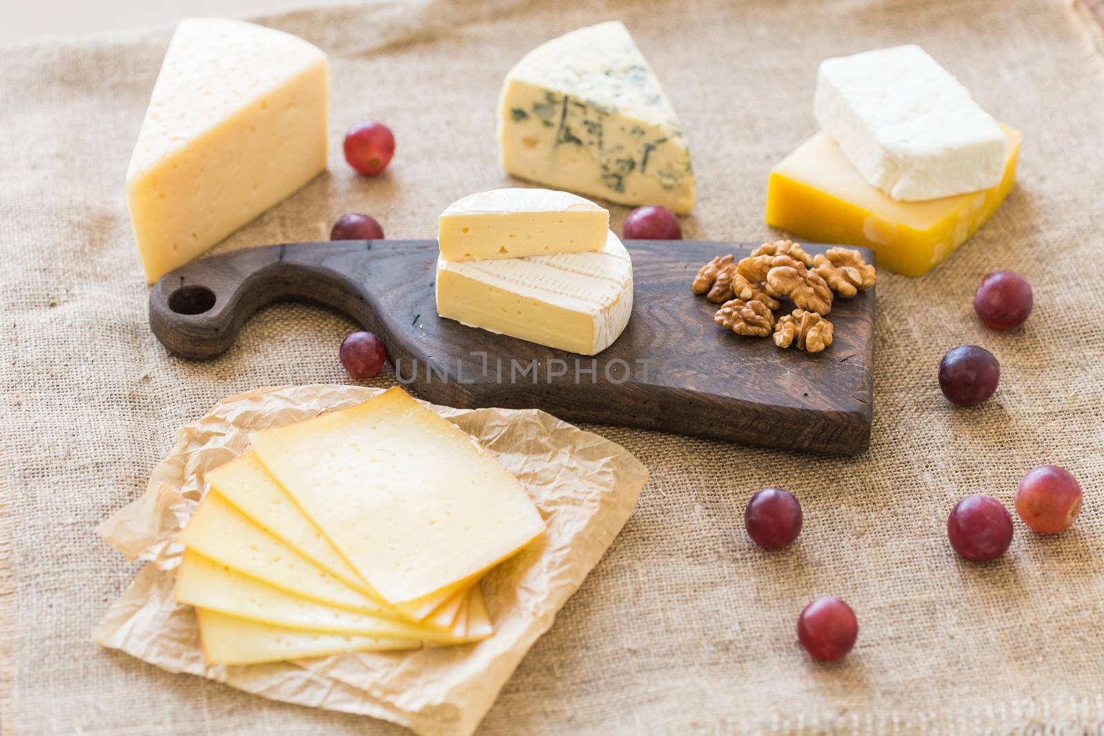 Fresh products. Cheese, brie, Camembert, grapes and nuts on rustic table. by Satura86