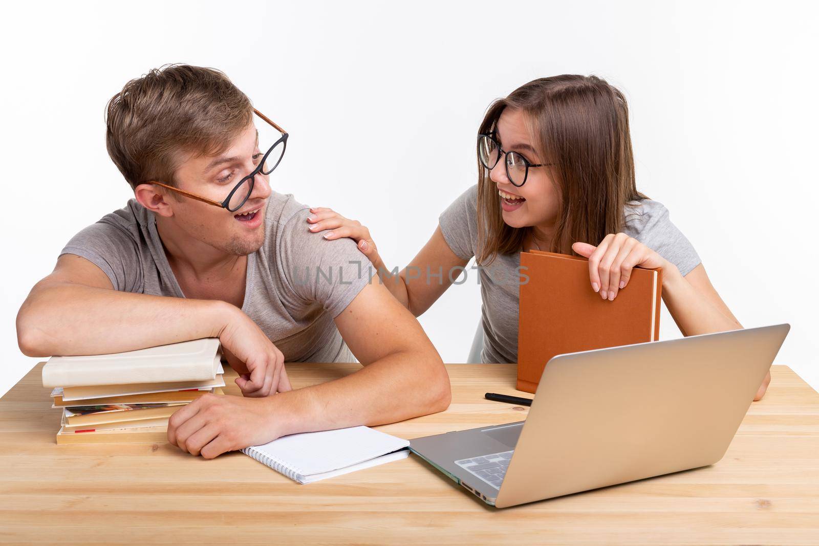 Education and student concept - a funny couple doing exercises or homework with laptop by Satura86