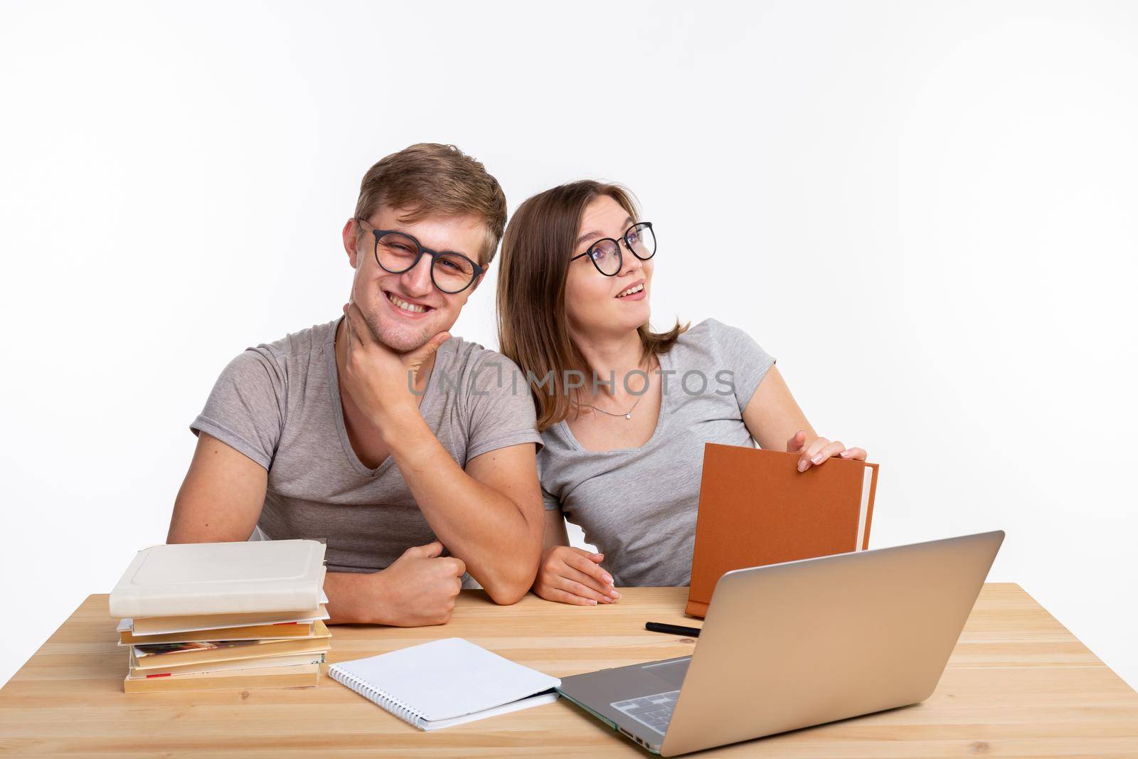Education and student concept - a funny couple doing exercises or homework with laptop by Satura86