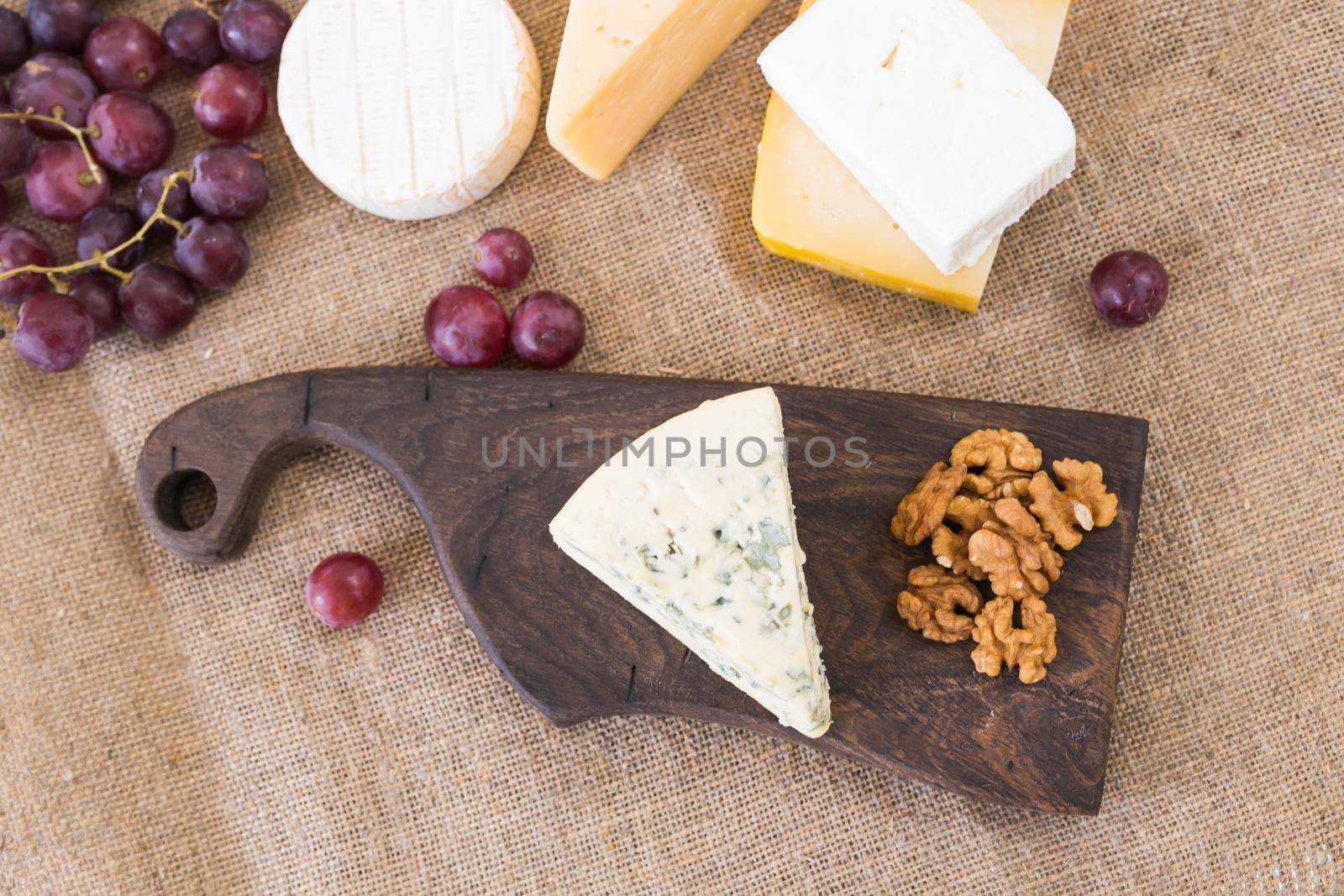 Fresh products. Cheese, brie, Camembert, grapes and nuts on rustic table. by Satura86
