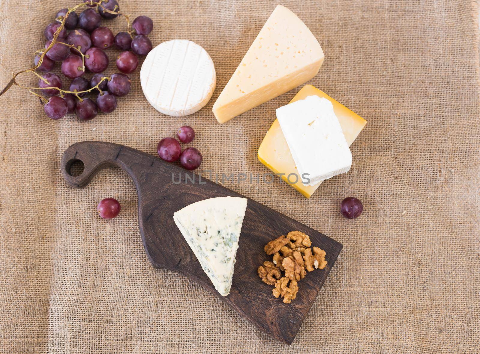 Cheese party table, perfect holiday appetizer with nut on rustic wooden board by Satura86