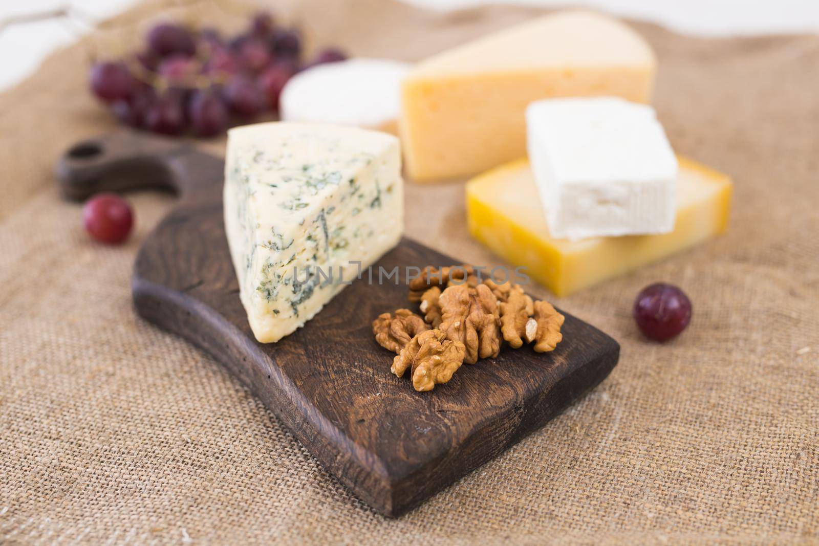 Cheese party table, perfect holiday appetizer with nut on rustic wooden board.