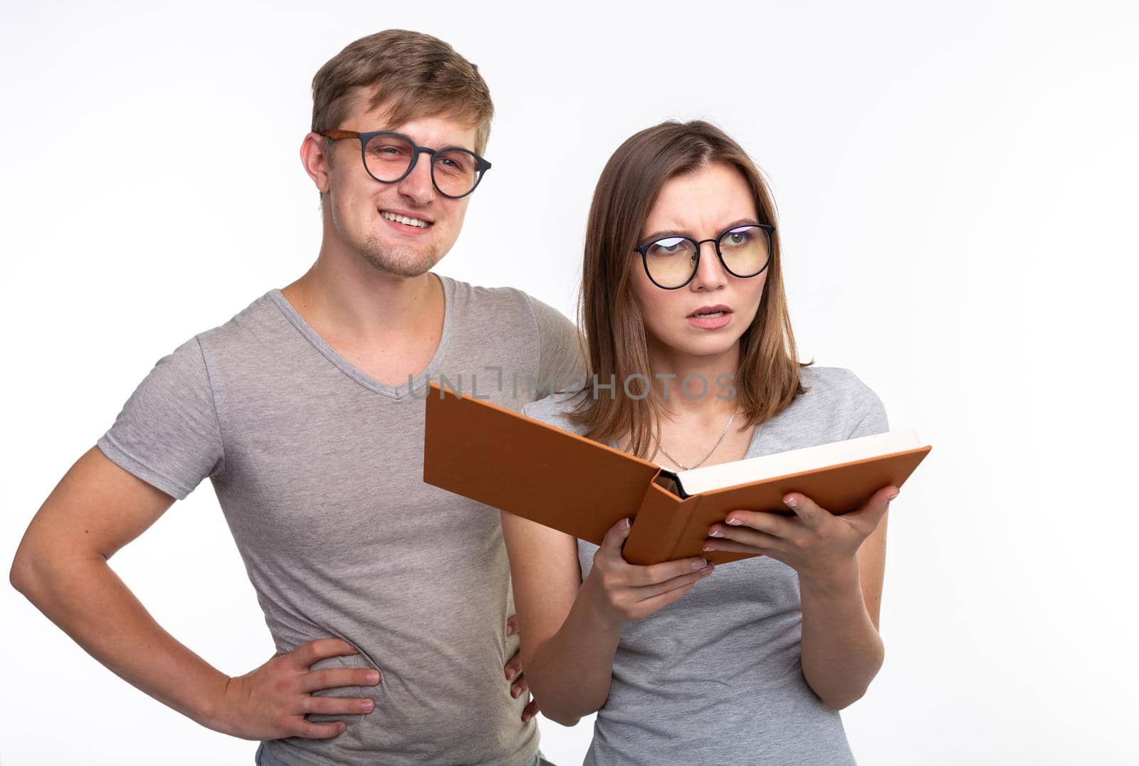 Studying together, people concept - a couple of young people reading a book.
