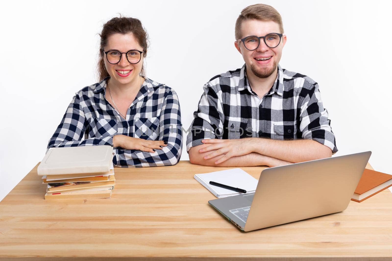 People and education concept - Two students dressed in plaid shirt sitting at a table.