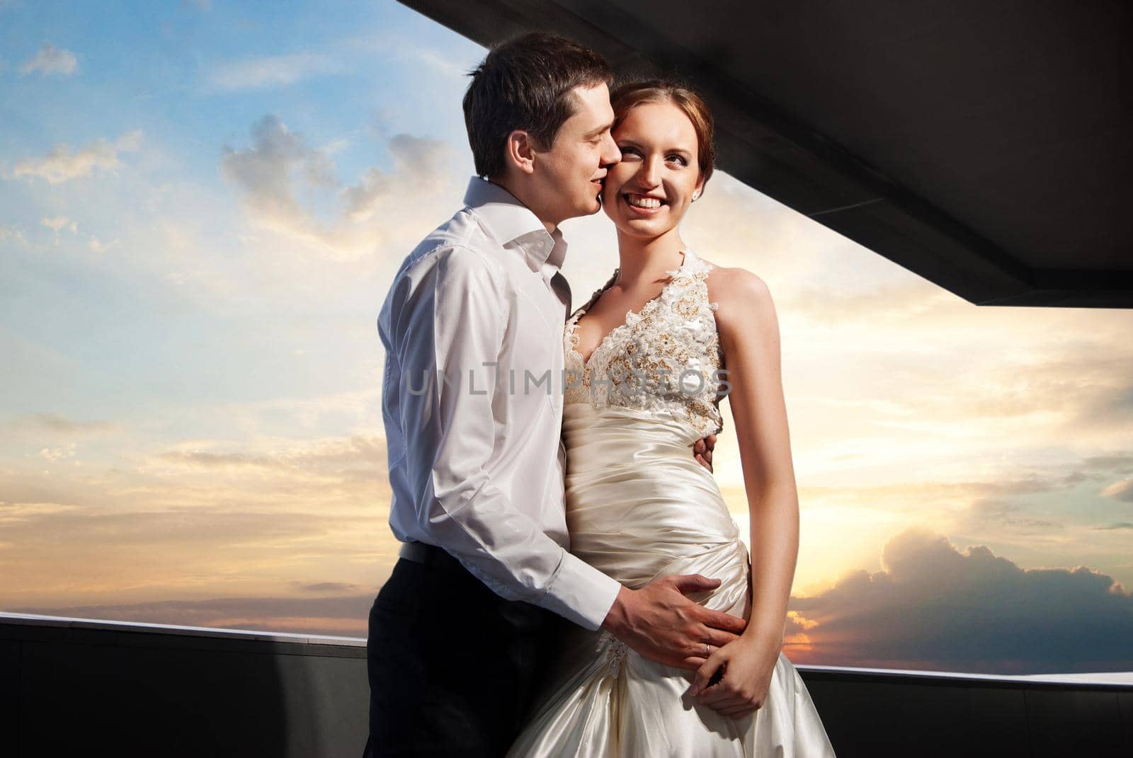 Happy bride and groom at the wedding walk in front of sunset in city