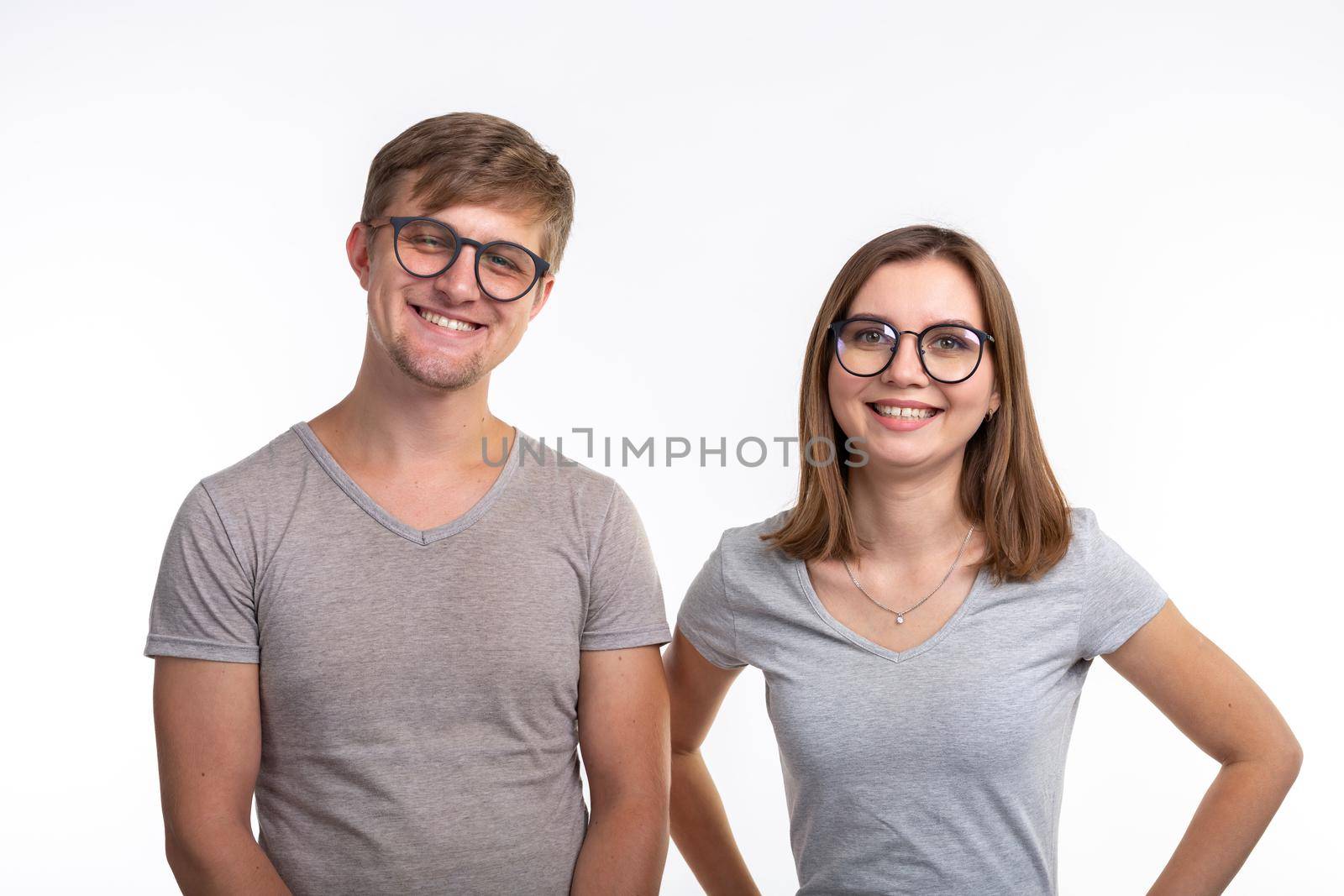 People and education concept - Two young funny student with thoughtful faces over white background by Satura86