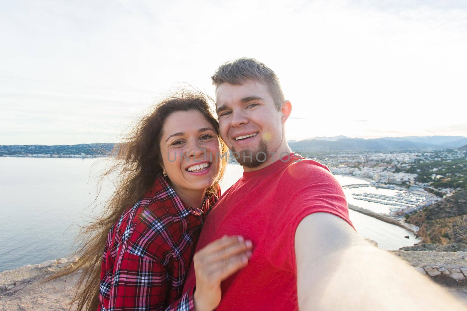 Travel, vacation and holiday concept - Beautiful couple having fun, taking selfie over beautiful landscape.