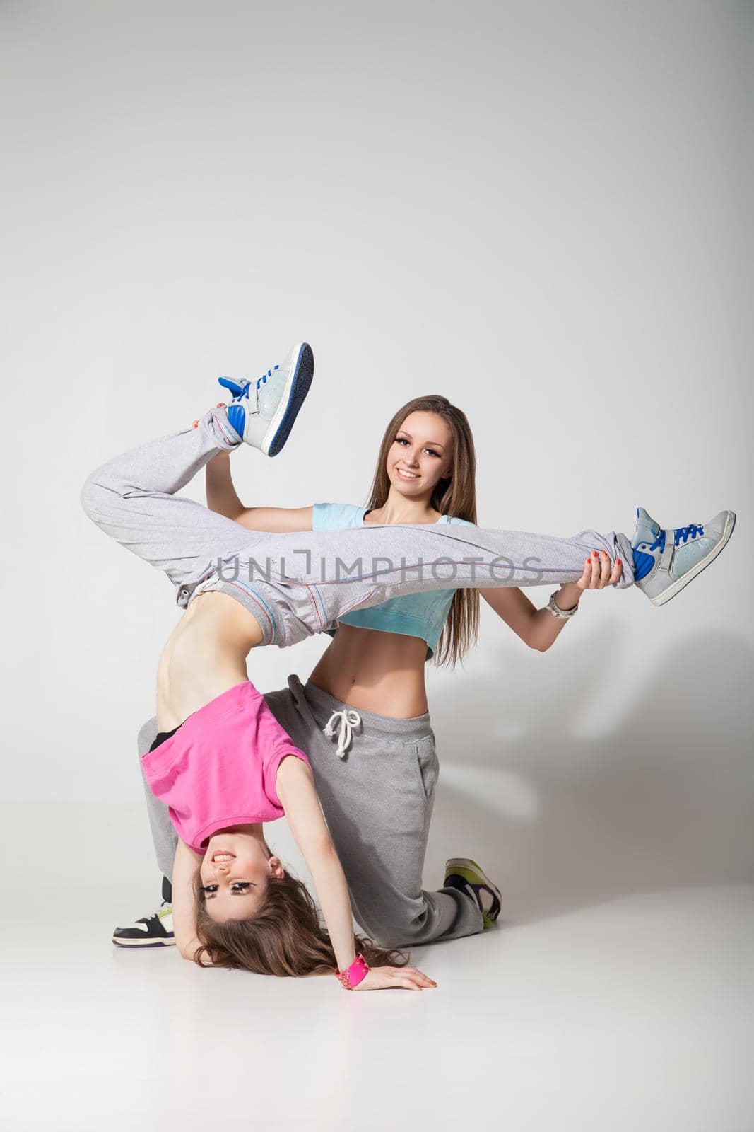 cool looking two dancing women on grey background